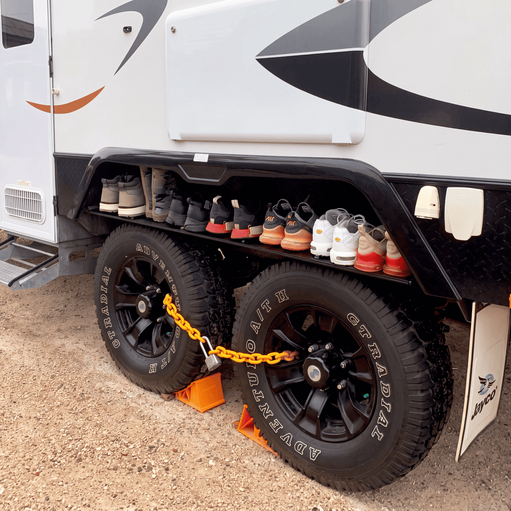 The wheel arch shelf shown fitted to a caravan at a campsite
